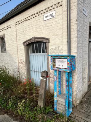 Boekenruilkastje aan een kapel met witte muur