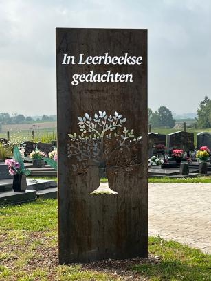 Stalen frame op  begraafplaaats met boom en opschrift 'In Leerbeekse gedachten'